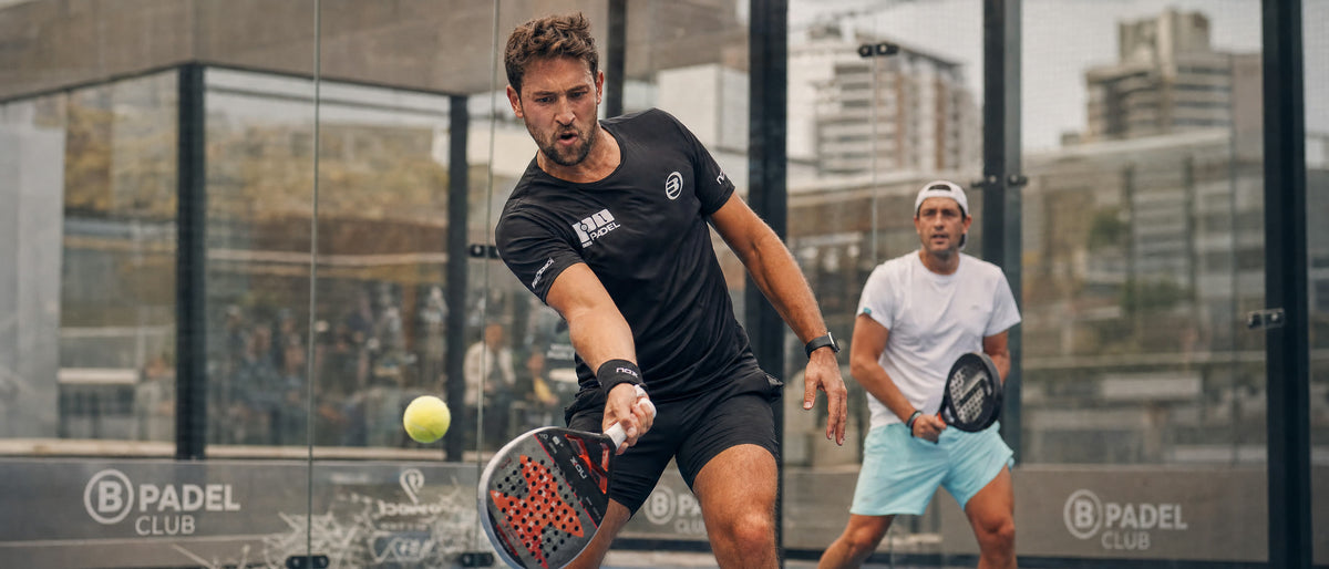 Partido de pádel en una cancha acristalada